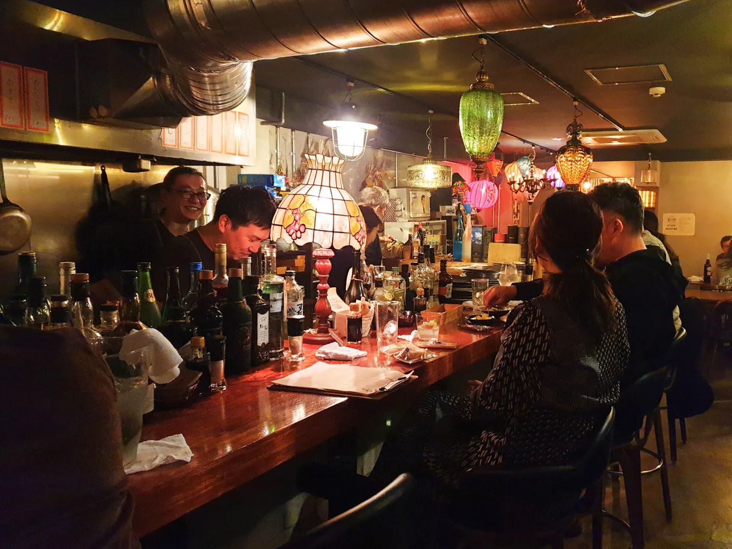 Guests seated at the counter of a small Kyoto bar