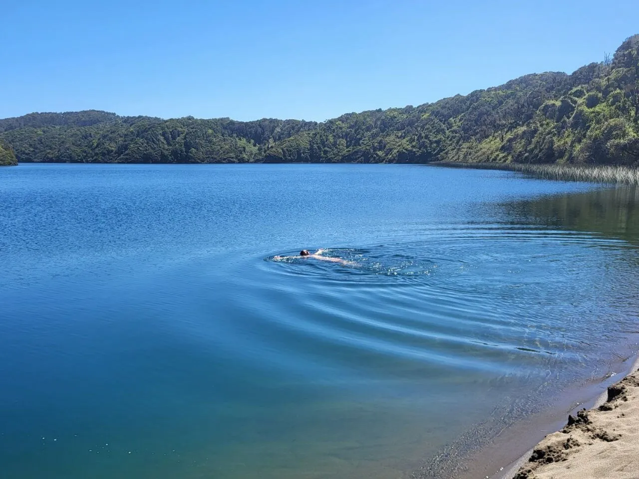 Bañista en una laguna azul cerca de Playa Colún