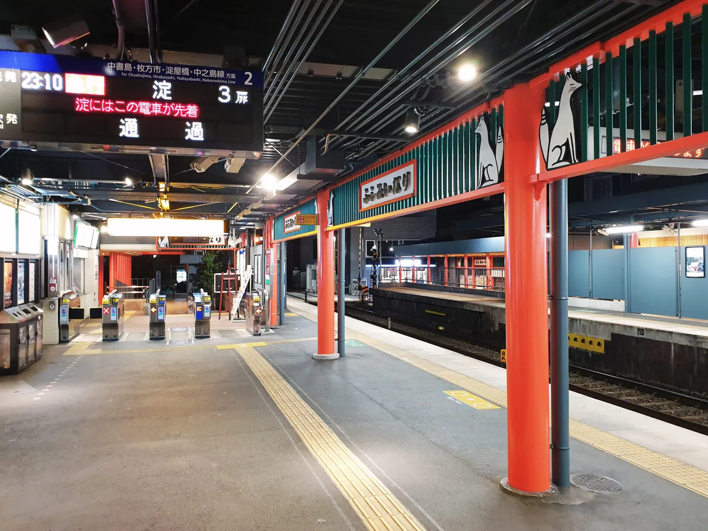 Red columns and fox decorations on a Kyoto station platform